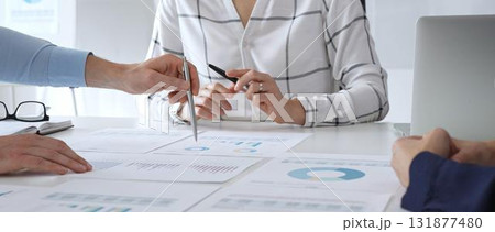 Business meeting with colleagues discussing financial charts, strategy planning, and analyzing data reports during a professional teamwork collaboration session 131877480