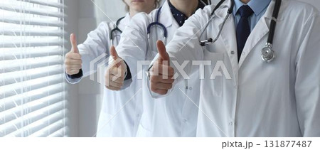 Medical team showing thumbs up gestures, symbolizing healthcare success, collaboration, good results, excellent medical service, and professional doctor approval 131877487