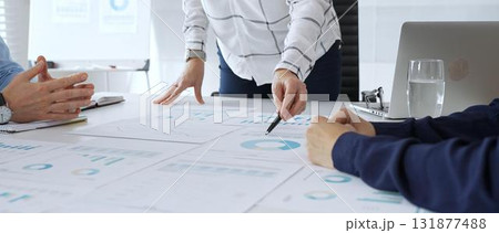 Business team analyzing financial charts during strategy meeting, professionals discussing data and performance metrics at workplace for decision making success 131877488