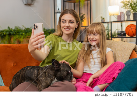 Mother daughter dog selfie joke with fun filter masks laugh together with smartphone playful family 131877705