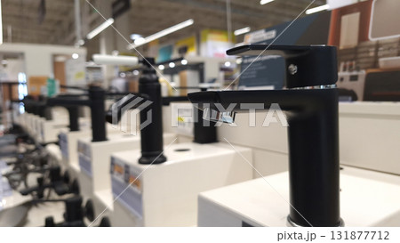 Modern black faucets on display in home improvement store 131877712