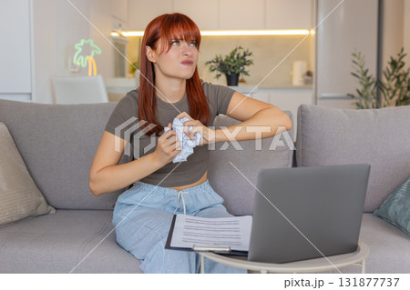 Young woman crumples wrong invoice tosses near laptop plans to print new corrected bill clean copy 131877737
