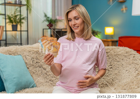 Pregnant woman counting euro cash money planning budget for childbirth calm financial security 131877809