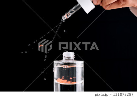The serum sprays from a cosmetic pipette on a black background. Beautiful drops. 131878287