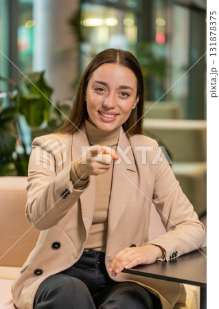 Portrait of Caucasian young businesswoman pointing to camera selecting hire sitting in office lobby 131878375
