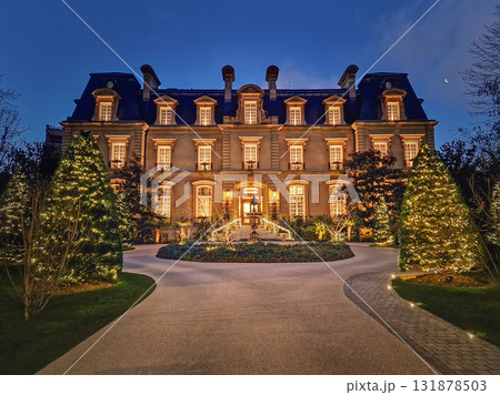 Paris, France - December 26, 2024 Beautiful nighttime view of the Saint James Hotel, a grand neoclassical chateau. The elegant mansion is framed by Christmas trees decorated with festive holiday light 131878503
