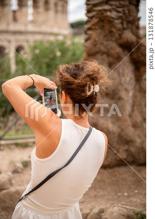 Woman taking photo with smartphone near ancient building outdoors Woman taking photo with smartphone near ancient building outdoors 131878546