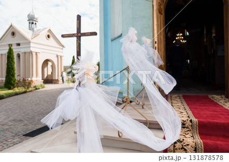 Rustic Church Wedding Decor: White Ribbons and Crosses at Entrance, Red Carpet and Floral Arrangement, Pastoral Scene, Warm Light. Rustic Church Wedding Decor: White Ribbons and Crosses at Entrance, Red Carpet and Floral Arrangement, Pastoral Scene, Warm Light. 131878578