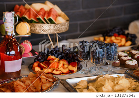 Luxurious Fruit Platter and Champagne Spread on Dark Counter, Elegant Catering Presentation, Rich Colors, Festive Mood Luxurious Fruit Platter and Champagne Spread on Dark Counter, Elegant Catering Presentation, Rich Colors, Festive Mood 131878645