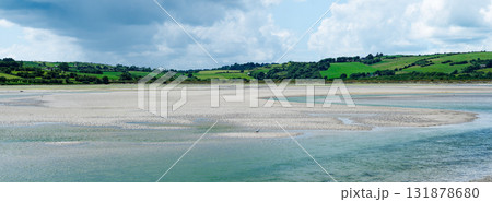 Green hills descend into the shallows of clear waters, a scene of natural wonder. 131878680