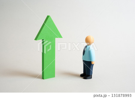 An office worker looks at a green growth arrow. Assess growth and success. Be a role model. Business success. Motivation, professional achievement, and goal setting. Personal development 131878993