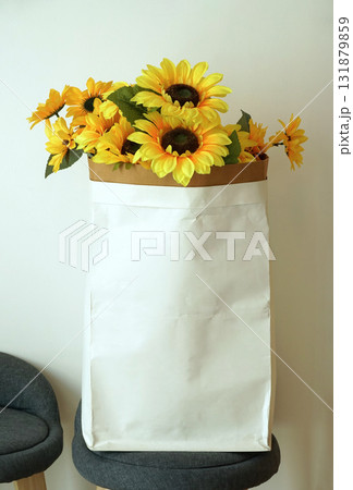 artificial sunflower In an empty paper bag for storing content, Place on a chair for a vintage style home or shop decoration. 131879859