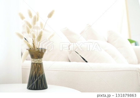 Soft grass feather flower In a wooden vase on the table in a bright living room with a white sofa set as the background and empty space for content Soft grass feather flower In a wooden vase on the table in a bright living room with a white sofa set as the background and empty space for content 131879863