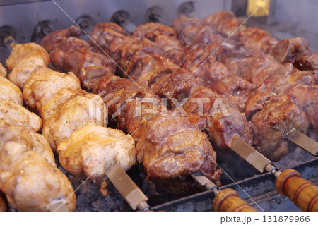 Kebabs on skewers are grilled on hot coals 131879966