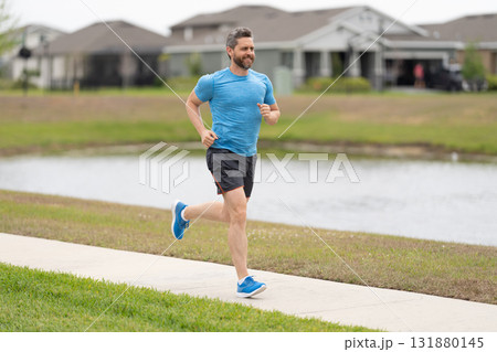Jogging activity. Running man run down the river. Jogging man enjoy the freedom of running outdoor. Man runner running training during the run. Sport fit runner jogging. Athlete activity 131880145