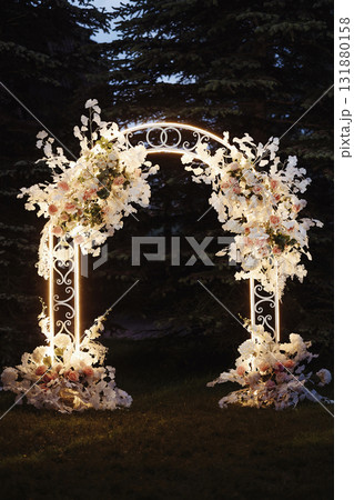 Wedding floral arch with white and pink flowers in garden at sunset 131880158