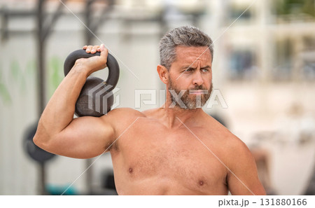 Sport athlete man hold kettlebell. Weightlifting kettlebell training. Hispanic man exercising with kettlebell outdoor. Man athlete lifting kettlebell. Athletic man do sport exercise. Gym workout Sport athlete man hold kettlebell. Weightlifting kettlebell training. Hispanic man exercising with kettlebell outdoor. Man athlete lifting kettlebell. Athletic man do sport exercise. Gym workout 131880166
