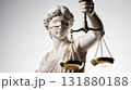 Blindfolded Lady Justice holding golden balance scales 131880188