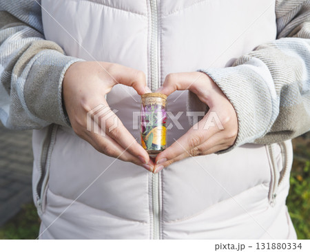 Proficiency in floristic. Close up of male and female hands holding glass terrarium with mini succulent garden. Multicultural flower store workers creating visually striking floral arrangement. Proficiency in floristic. Close up of male and female hands holding glass terrarium with mini succulent garden. Multicultural flower store workers creating visually striking floral arrangement. 131880334