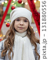 Portrait of a young girl in a white winter hat and scarf for the Christmas season 131880556