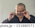 Man adjusting glasses in a thoughtful portrait, conveying focus and professionalism 131880571