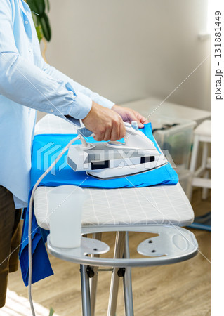 Ironing clothes at home in a cozy living space during daytime 131881449