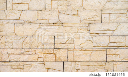 Yellow decorative stone wall with geometric blocks and detailed chiseled texture. Concept of modern architecture, structure, building aesthetics. Natural background, copy space Yellow decorative stone wall with geometric blocks and detailed chiseled texture. Concept of modern architecture, structure, building aesthetics. Natural background, copy space 131881466
