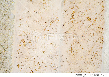 Close-up of porous beige limestone texture with fossil inclusions and weathered surface. Concept of natural erosion, geology and stone aging. Natural background, copy space 131881472