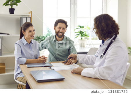 Young married couple signs contract with doctor in modern obstetrics and gynecology clinic. Young married couple signs contract with doctor in modern obstetrics and gynecology clinic. 131881722