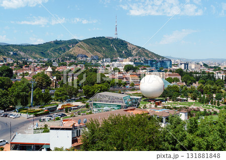 Vibrant cityscape of Tbilisi showcasing modern architecture and natural beauty under a sunny sky 131881848