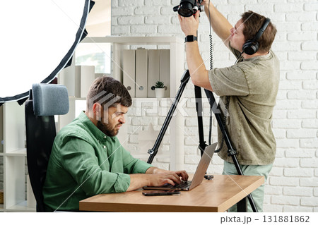 Professional video recording setup in a modern office with two focused individuals Professional video recording setup in a modern office with two focused individuals 131881862