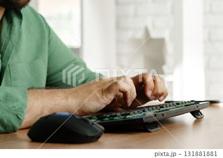 Person typing on keyboard at a desk in a bright workspace during the day Person typing on keyboard at a desk in a bright workspace during the day 131881881