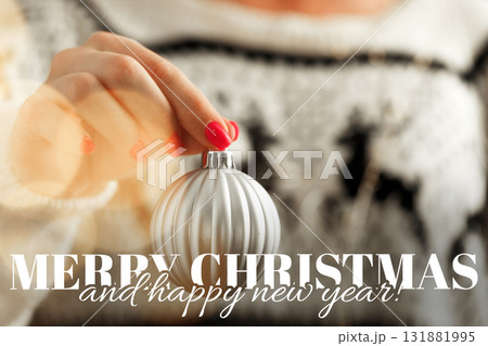 Creating holiday decorations with a silver ornament during festive season in cozy setting 131881995