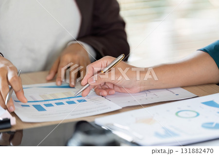 Collaboration and Business Strategy. Professionals discussing vital business metrics with focus on data analysis and cooperation. Collaboration and Business Strategy. Professionals discussing vital business metrics with focus on data analysis and cooperation. 131882470
