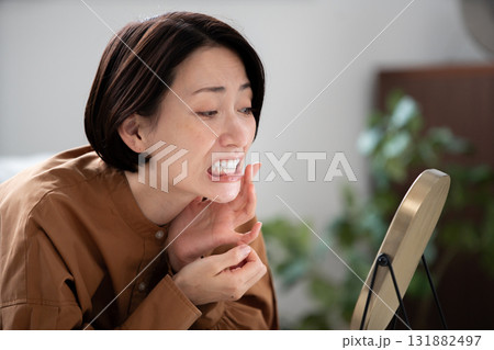 歯を鏡で確認する女性 131882497