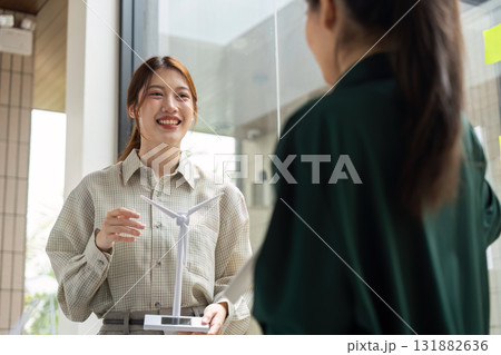 Collaboration and Sustainable Solutions. A team discussing renewable energy models with enthusiasm. 131882636