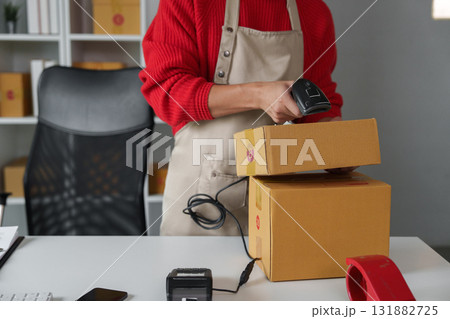 Product Preparation and Shipping. An online seller scanning items for shipment in a professional workspace. Product Preparation and Shipping. An online seller scanning items for shipment in a professional workspace. 131882725