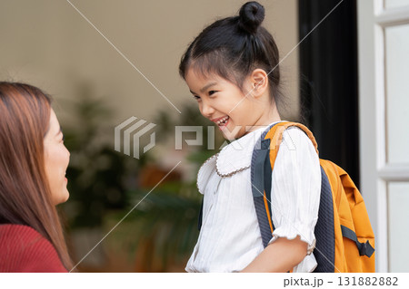 Smiles and Confidence. A girl shares a heartfelt moment with her mother before leaving for school. Smiles and Confidence. A girl shares a heartfelt moment with her mother before leaving for school. 131882882