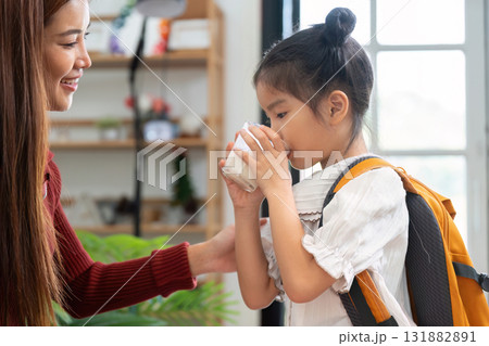 A Moment of Anticipation and Care. A little girl drinks milk with anticipation for her first day of school. A Moment of Anticipation and Care. A little girl drinks milk with anticipation for her first day of school. 131882891