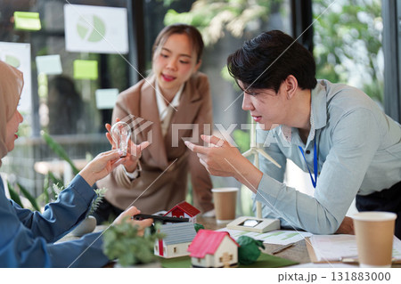 Sustainable Solutions and Team Collaboration. A group discussing eco-friendly building models and renewable energy concepts. Sustainable Solutions and Team Collaboration. A group discussing eco-friendly building models and renewable energy concepts. 131883000