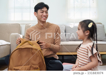 Back to School and Learning. A joyful interaction between a father and daughter as they prepare for school, showcasing essential supplies. Back to School and Learning. A joyful interaction between a father and daughter as they prepare for school, showcasing essential supplies. 131883074