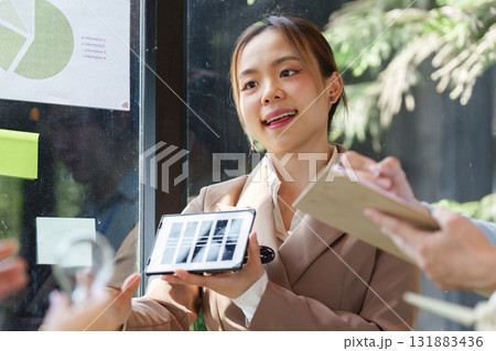 Renewable Energy and Collaboration. A professional presenting solar panel technology to an engaged audience. Renewable Energy and Collaboration. A professional presenting solar panel technology to an engaged audience. 131883436