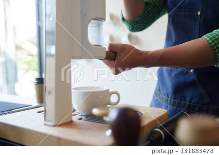 Sustainable Innovation and Coffee Preparation. A barista uses modern equipment to craft coffee, focusing on sustainable methods. Sustainable Innovation and Coffee Preparation. A barista uses modern equipment to craft coffee, focusing on sustainable methods. 131883478