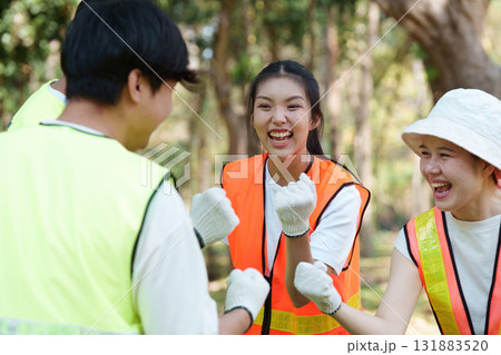 Celebrating teamwork. Volunteers bonding during a successful park cleanup. Celebrating teamwork. Volunteers bonding during a successful park cleanup. 131883520