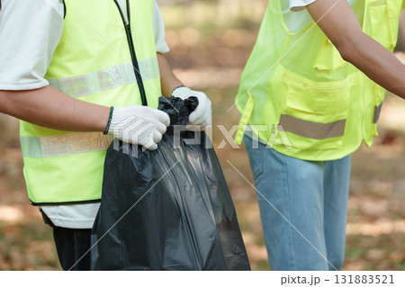 Active participation. Volunteers engaging in garbage collection for a cleaner future. Active participation. Volunteers engaging in garbage collection for a cleaner future. 131883521