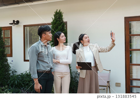 Real estate showing. A real estate agent presenting a property to clients, illustrating home features and engagement. 131883545