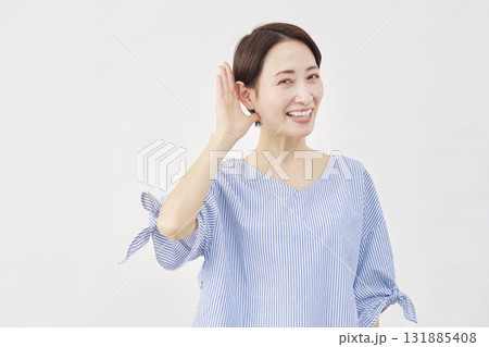 女性　ミドルエイジ　耳に手を当てて聞くジェスチャー　白背景　 カメラ目線 131885408