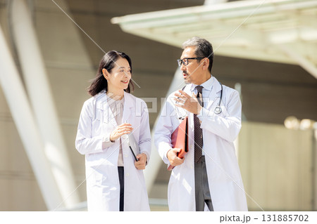 歩く白衣を着た男女 131885702