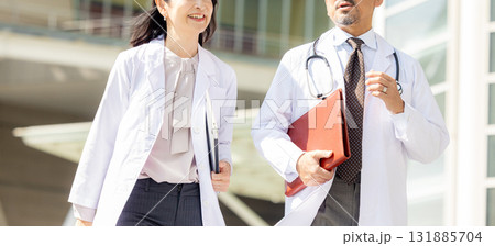 歩く白衣を着た男女 131885704