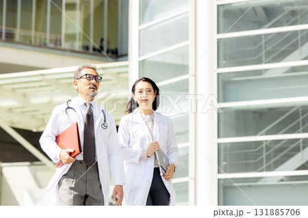 歩く白衣を着た男女 131885706